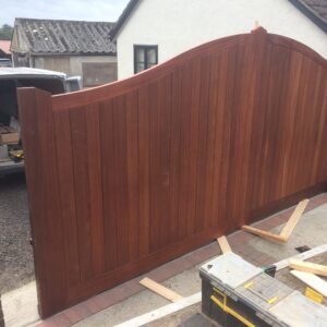 Bespoke omega top sliding driveway gates featuring hardwood tongue and groove infill, handcrafted in Hertfordshire and installed for an Essex property.