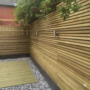A contemporary horizontal slatted garden fence screen built using premium planed landscape battens near Harlow.