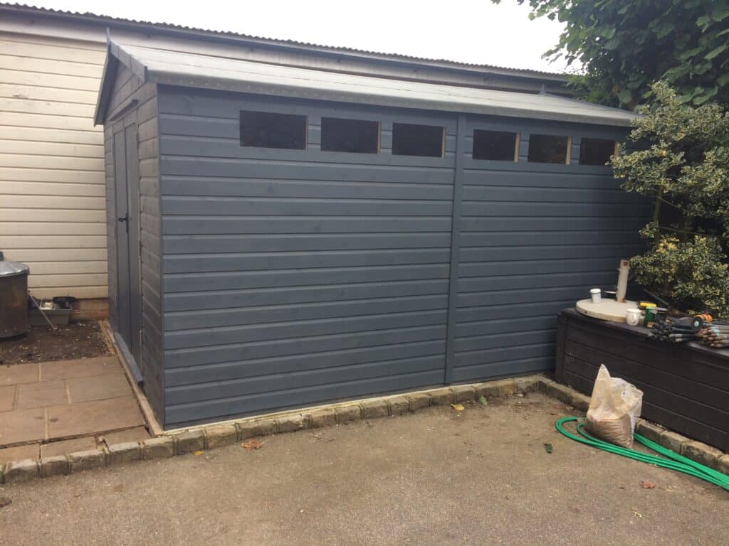 Modern dark grey garden shed with high-level windows, supplied by 414 Fencing & Timber Supplies.